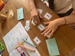 A child sorting phonics word cards during a one-to-one literacy session